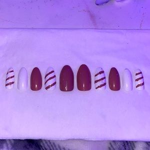 Nude pink and white nails with striped design.